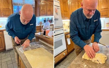 A man prepares dough on a kitchen counter, focusing on cutting and shaping it.